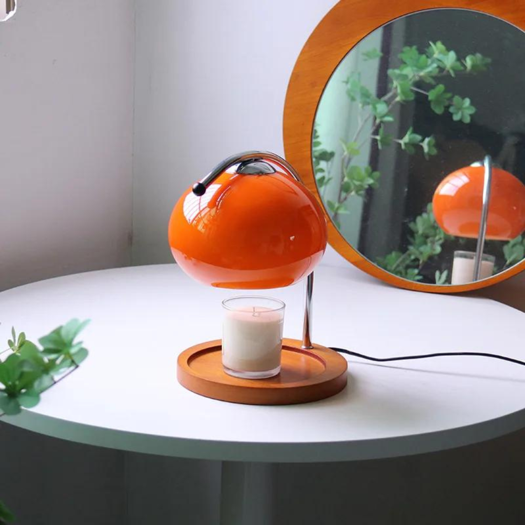 Orange Retro Glass Candle Warmer on a desk with a mirror