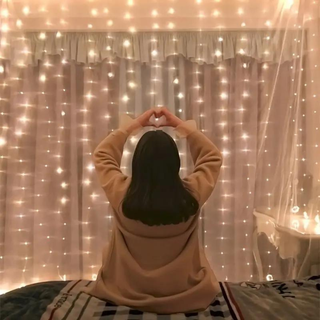 person making heart hands in front of Fairy Curtain String Lights